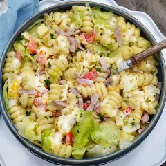 En stor skål med krämig pastasallad med skinka, paprika och sallad. Perfekt dressing till pastasallad för en sommarlunch.