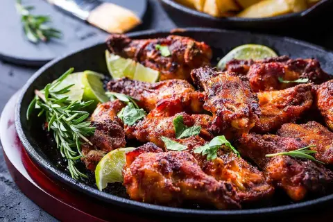 Saftiga, kryddiga kycklingvingar, perfekt marinerade och serverade med lime och rosmarin. En fest för smaklökarna!