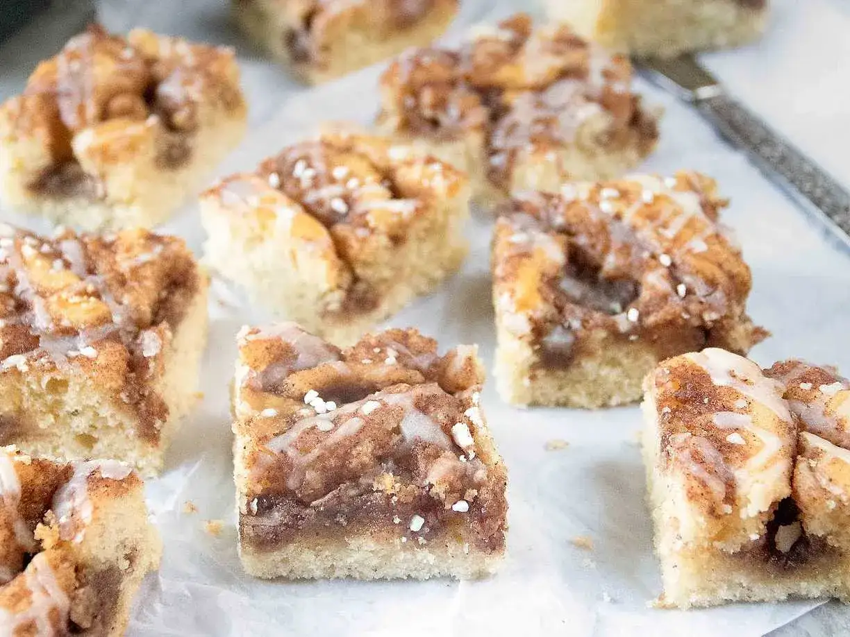 Kanelbullekaka i l&aring;ngpanna, skuren i fyrkantiga bitar med glasyr och p&auml;rlsocker. Perfekt f&ouml;r fikat!