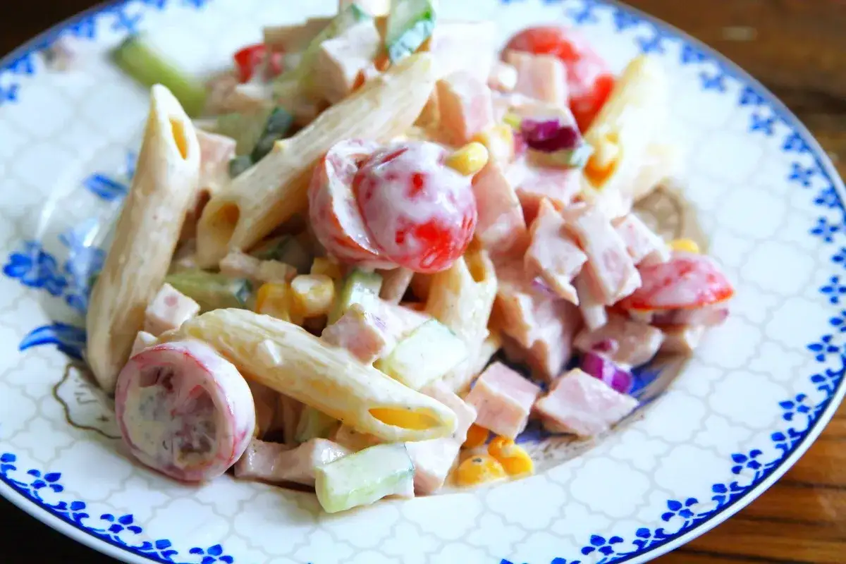 En kr&auml;mig pastasallad med skinka, penne, k&ouml;rsb&auml;rstomater, gurka och majs. Perfekt f&ouml;r en snabb lunch eller middag.