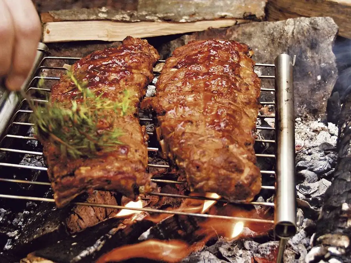 Spareribs grillas &ouml;ver &ouml;ppen eld, glaserade och med en kvist rosmarin.