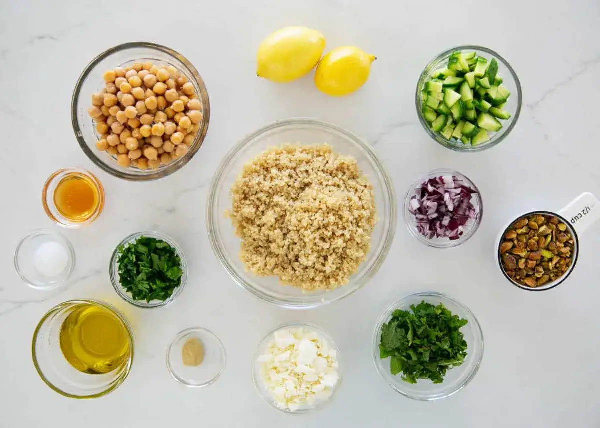 Ingredienser f&ouml;r jennifer aniston sallad recept: kik&auml;rtor, quinoa, gurka, r&ouml;dl&ouml;k, persilja, mynta, fetaost, pistagen&ouml;tter, citroner, olivolja, honung, senap och salt.