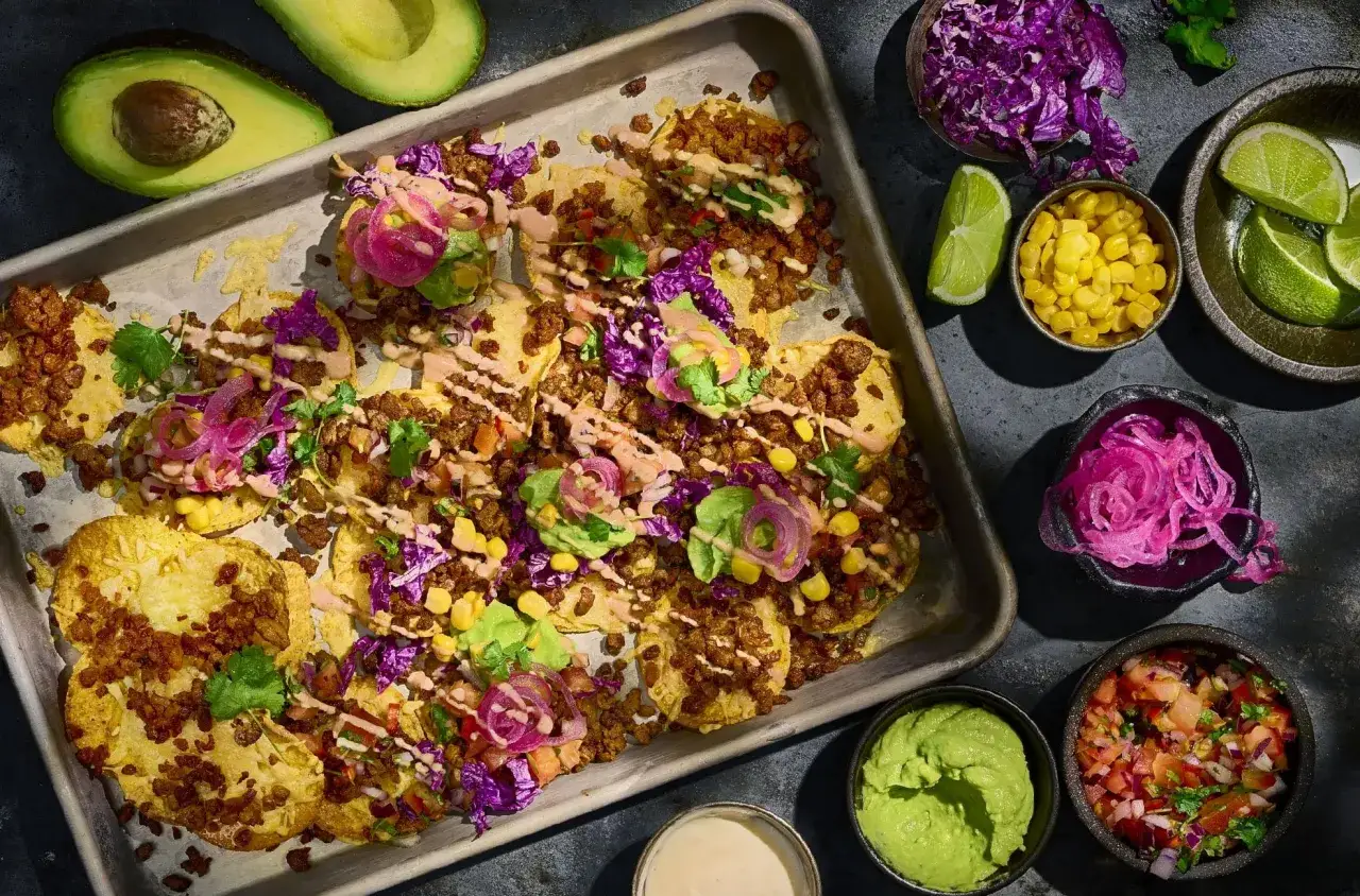 En bricka med tacos, toppade med k&ouml;ttf&auml;rs, l&ouml;k, majs, k&aring;l och avokado. Gott till tacos!