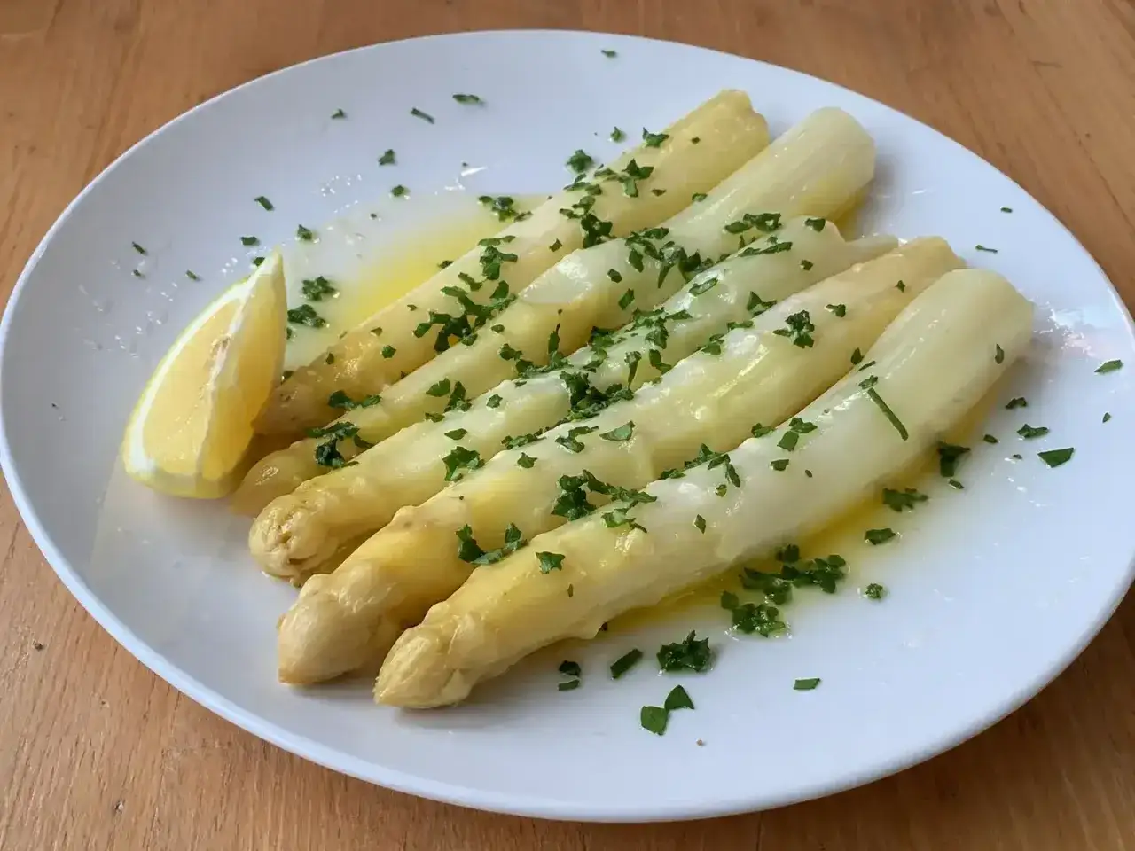 Vitt sparris, perfekt tillagad och serverad med sm&auml;lt sm&ouml;r, f&auml;rsk persilja och en citronklyfta. En enkel men uts&ouml;kt r&auml;tt att koka vit sparris till.