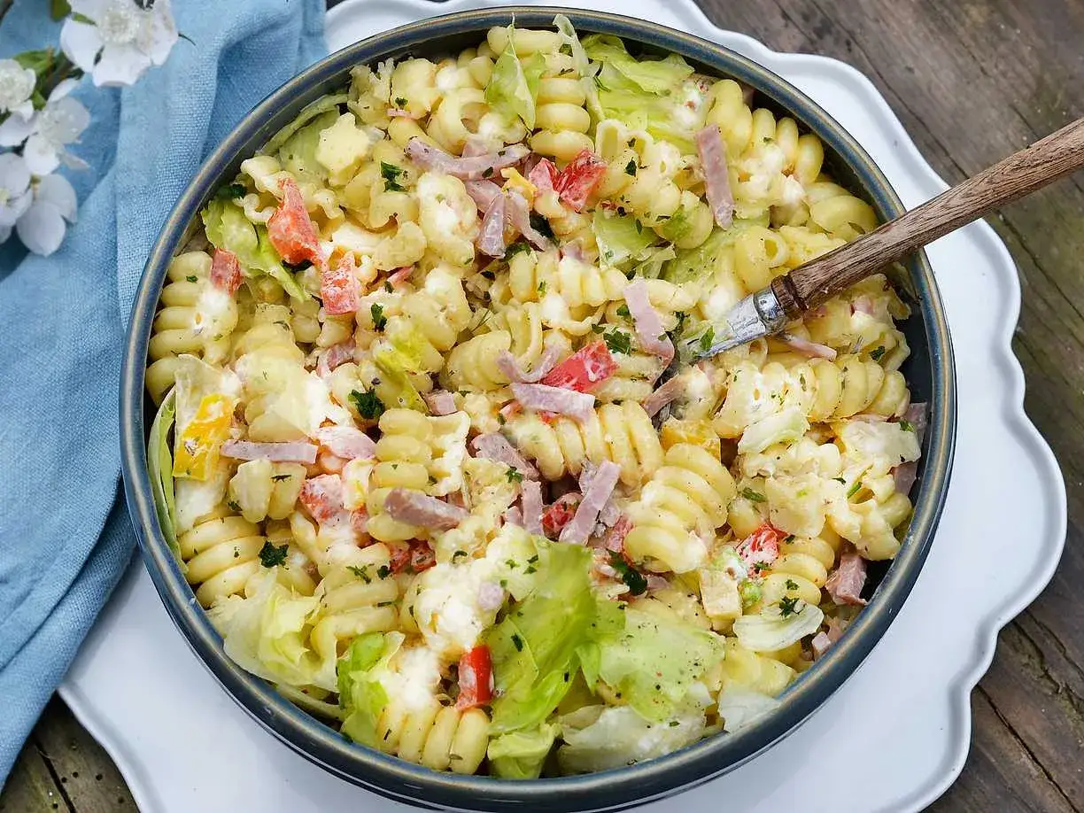 En stor sk&aring;l med kr&auml;mig pastasallad med skinka, paprika och sallad. Perfekt dressing till pastasallad f&ouml;r en sommarlunch.