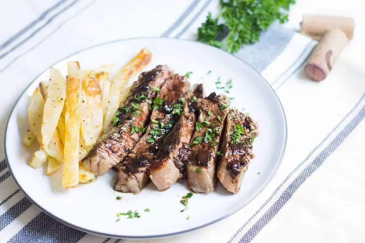 Skivad entrecote med perfekt innertemp, serverad med krispiga pommes frites och en m&ouml;rk s&aring;s.