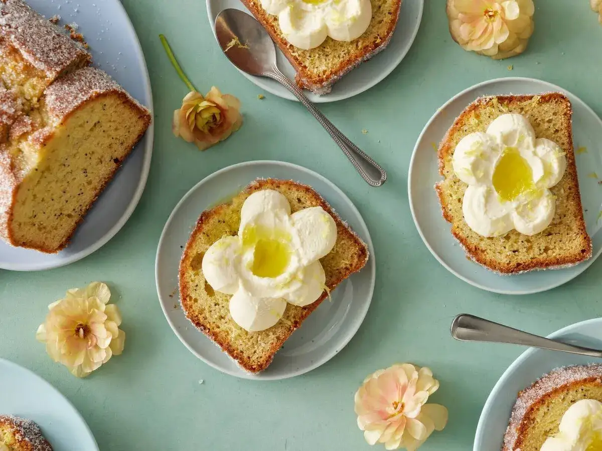 Citronkaka med fluffig grädde och en klick syrlig lemon curd, dekorerad med blommor.