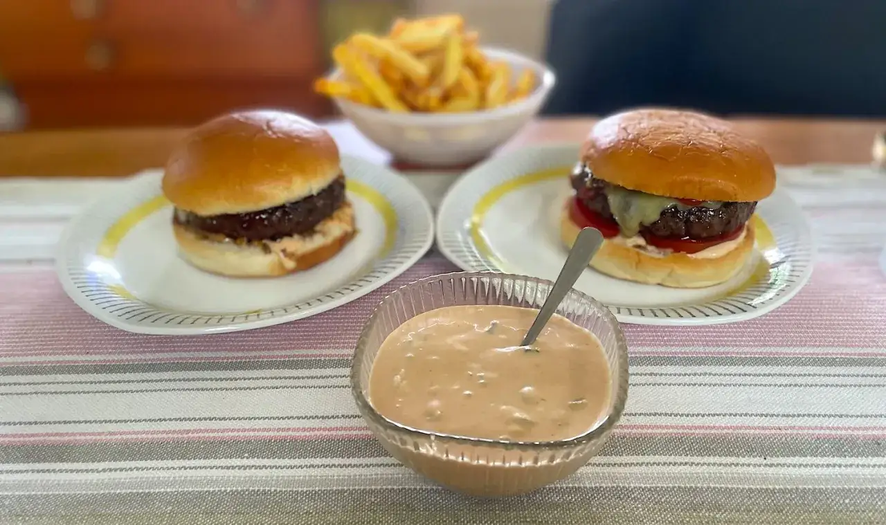 Tv&aring; saftiga hamburgare med pommes frites och en sk&aring;l med kr&auml;mig hamburgerdressing. Perfekt f&ouml;r en mysig hemmakv&auml;ll!