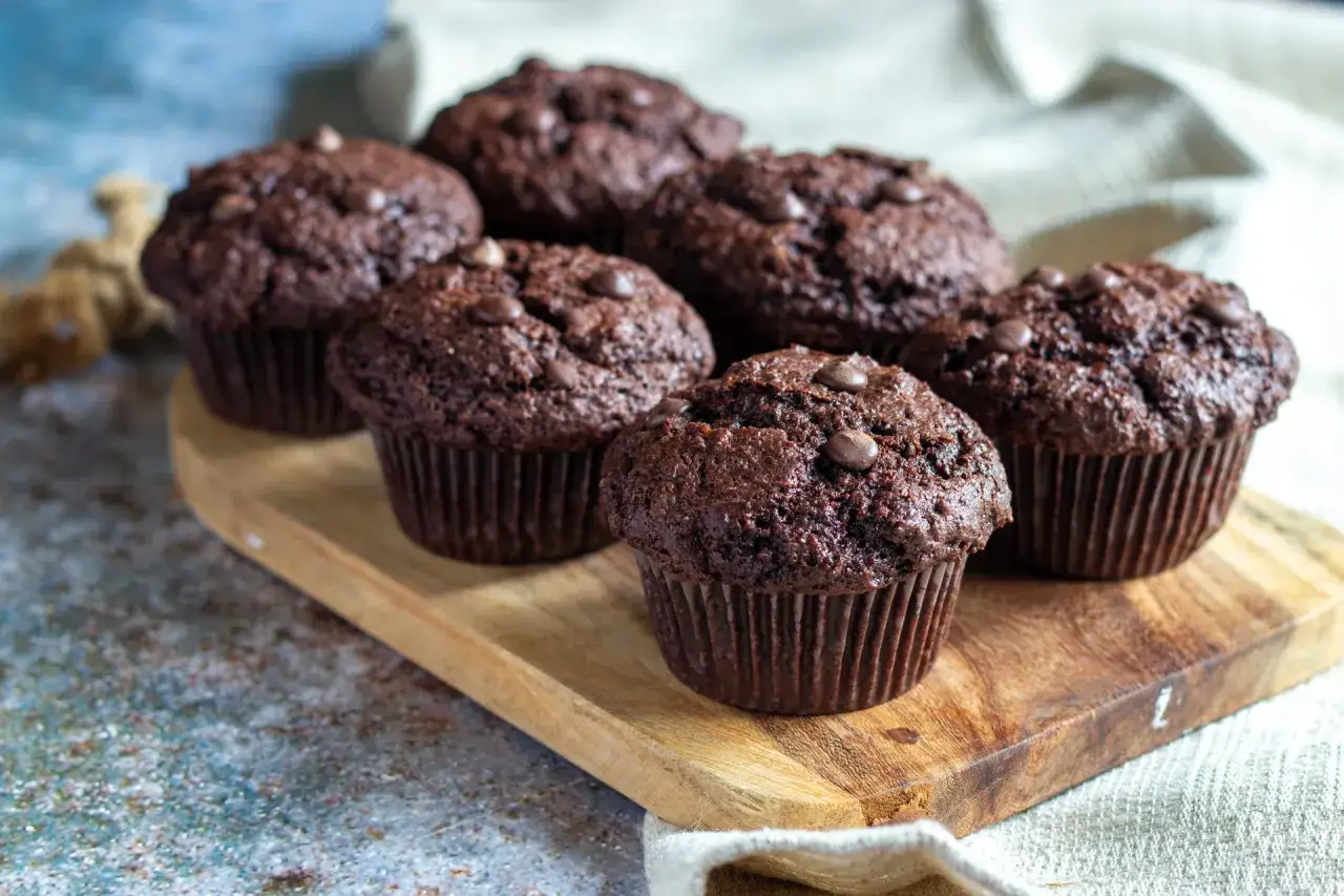 Muffins choklad med chokladbitar p&aring; en tr&auml;bricka. Perfekt f&ouml;r fikat!