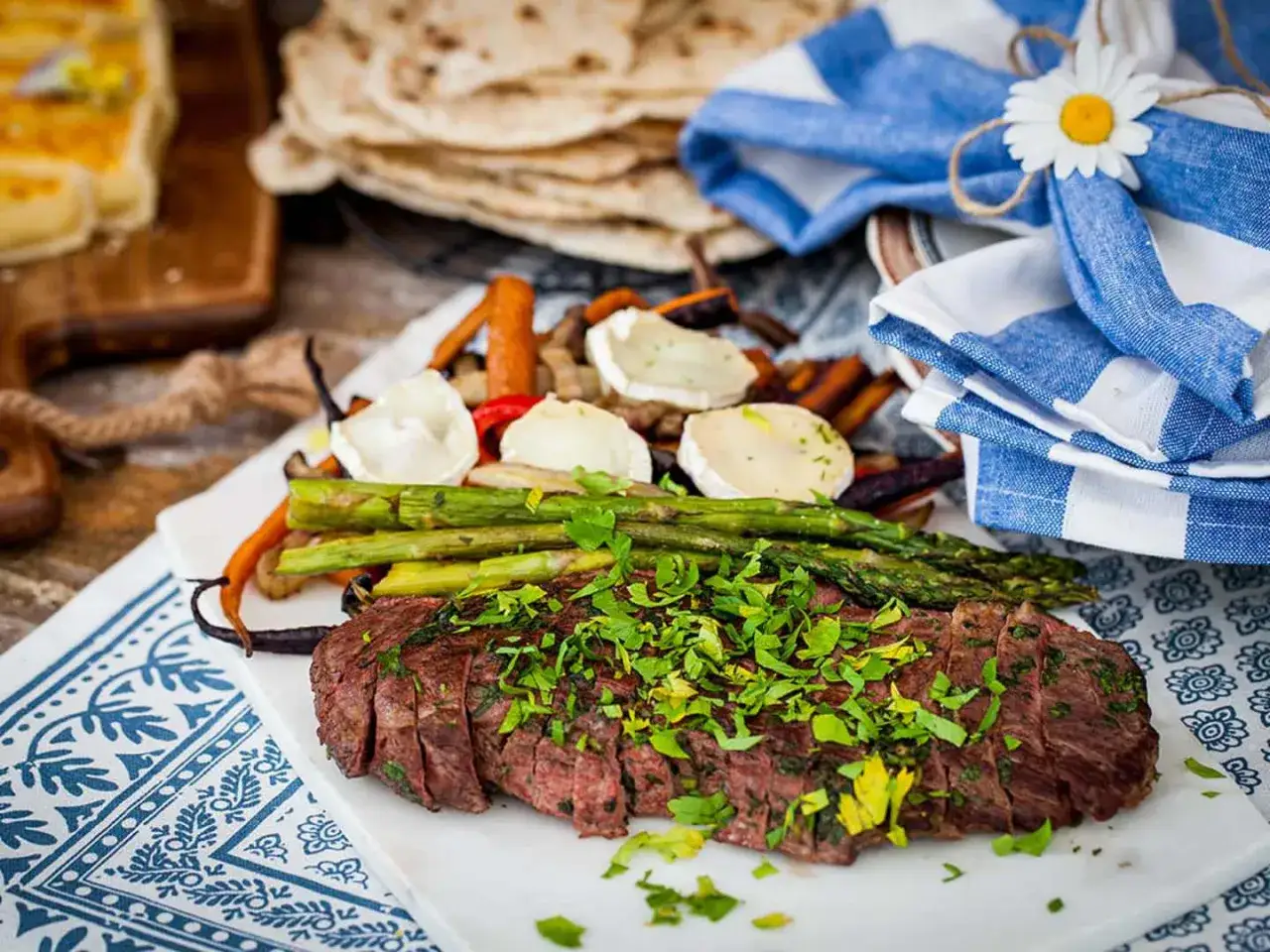 Skivad flankstek med örtmarinad, serverad med grillade grönsaker och getost. En festlig måltid!